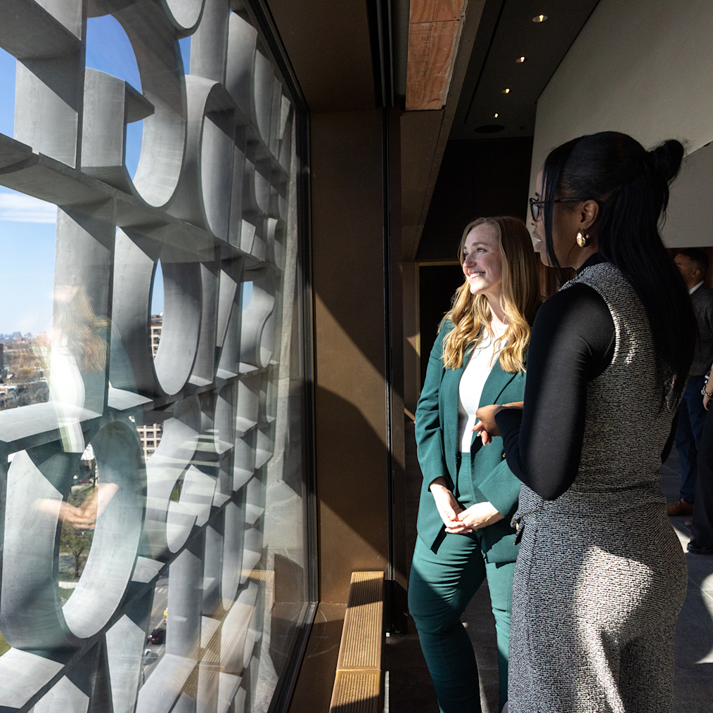 An image of two women looking at the “We Are America” installation in the Sky Room. 

