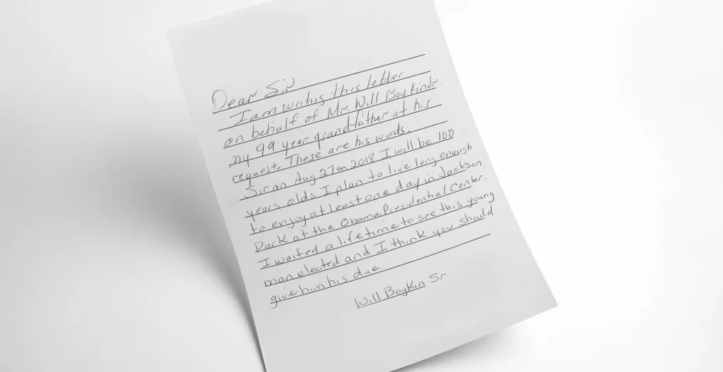A handwritten letter with black ink on white, lined paper. The letter explains that the sender's 99 year-old grandfather hopes to visit the Obama Presidential Center after a lifetime of waiting to see "this young man" elected.