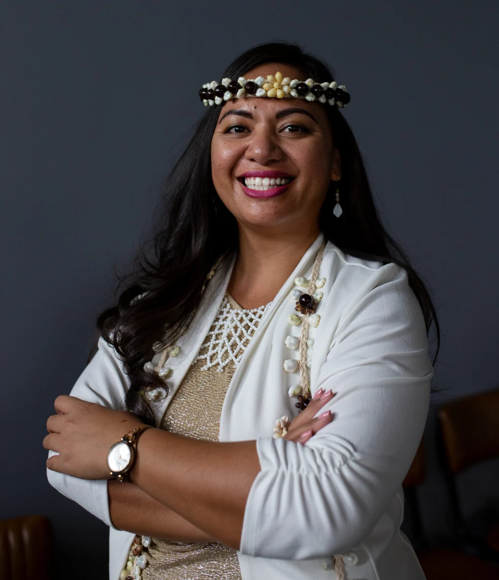 Sheila Babauta smiles to camera wearing a beaded headpiece.