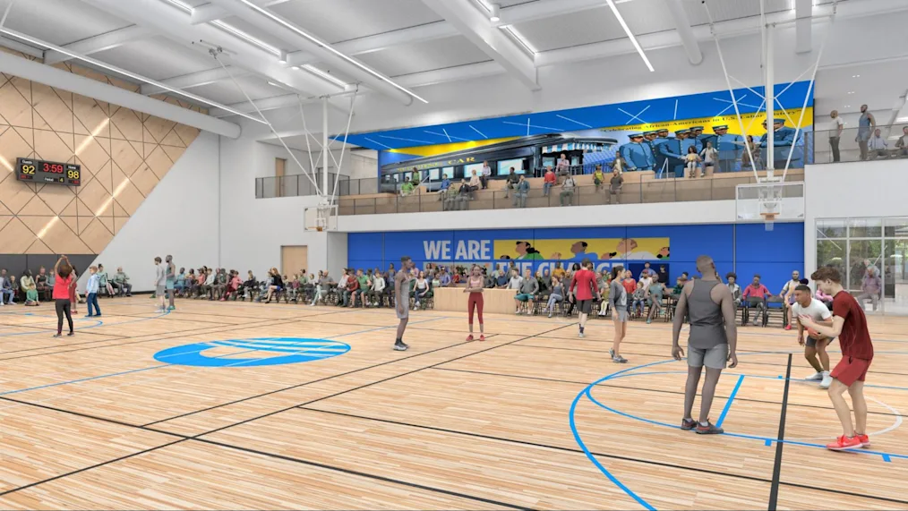 A rendering of Main Court at Home Court on the Obama Presidential Center campus. Main Court is a large basketball court with white ceilings and a wood basketball floor. On the floor is a blue logo of the Obama Foundation. On the left wall is the wood panel with a black scoreboard sitting on top of it. On the right wall are two levels of bleachers where people are seated. In the background are two levels of blue walls with murals on each. On the basketball court are several people wearing athletic gear.