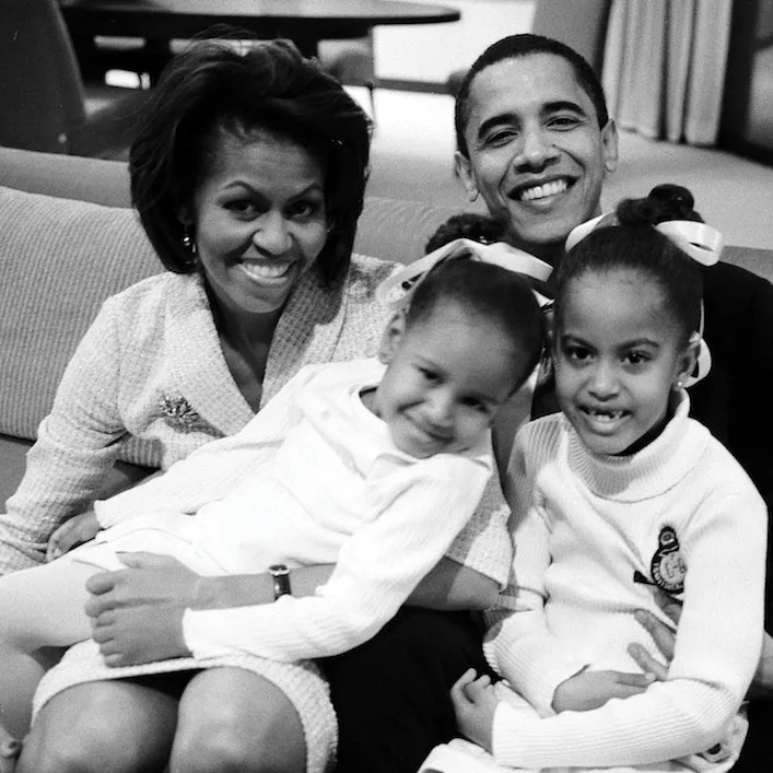 The Obama family smiles to camera.