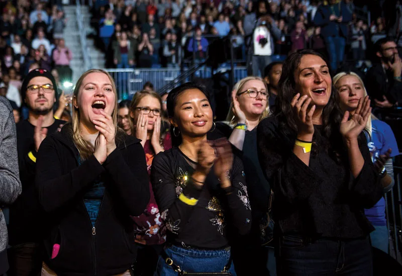 A group of young people screams and cheers during the closing concert of the Obama Foundation Summit.