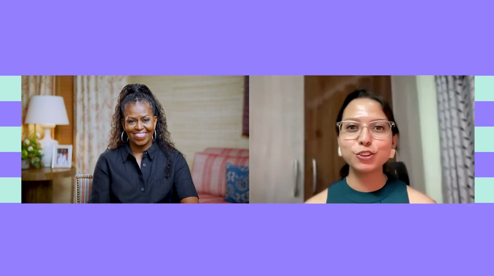 Michelle Obama sits in an online conversation with a girls’ education leader from Nepal who has dark hair pulled back and is wearing a teal shirt and glasses. The two smile in conversation together.