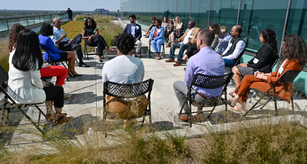 President and Mrs. Obama sit in a circle with the 2021 Scholars class outside the Obama Foundation office