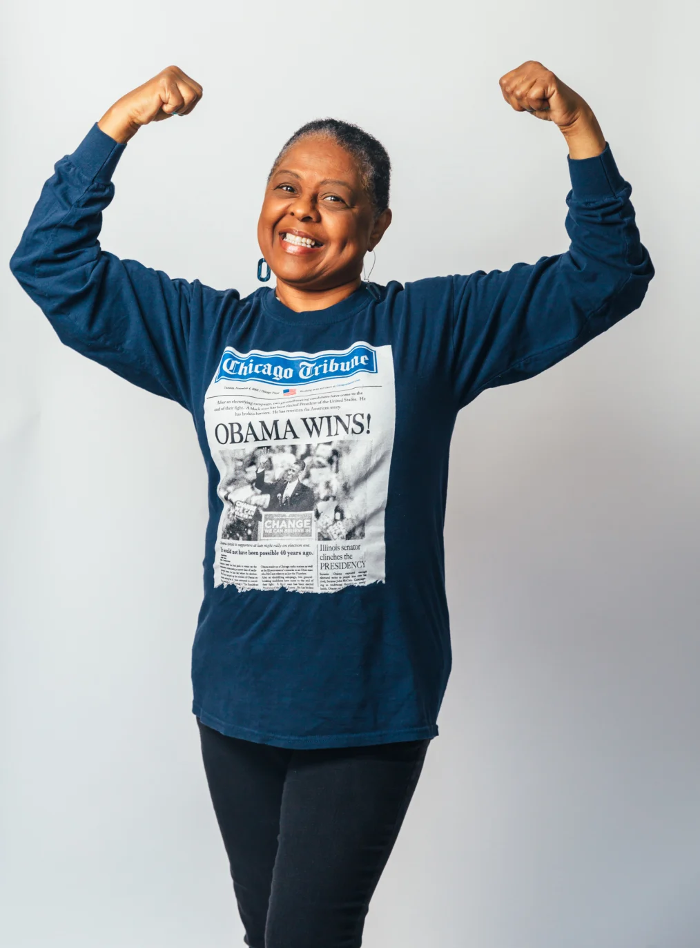 Marieth Mitchell poses with her arms over her head wearing the t-shirt she kept from President Obama's 2008 victory.