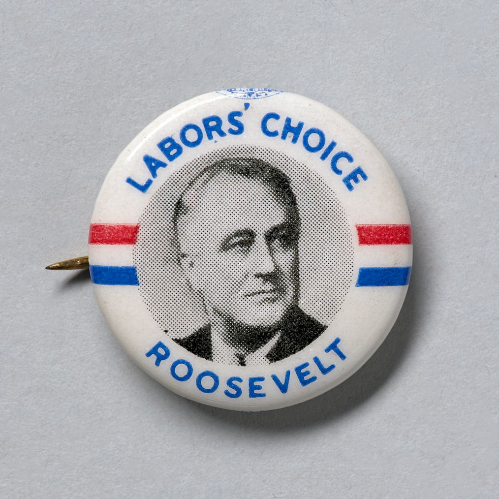 A white button with blue and red stripes and a photo of Franklin D. Roosevelt