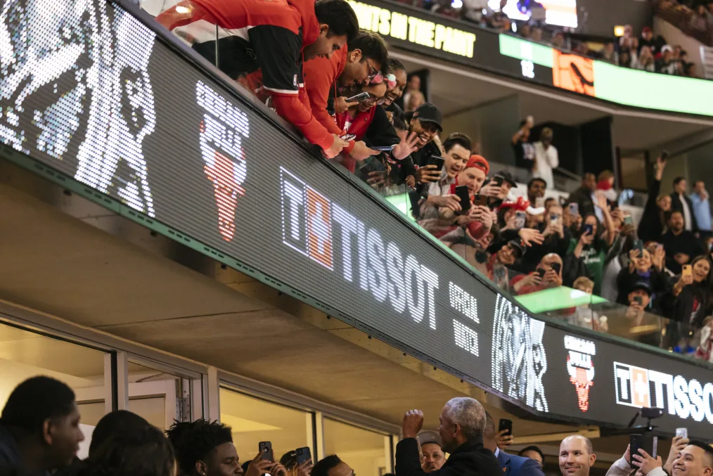 President Obama celebrated while interacting with people at a Chicago Bulls game