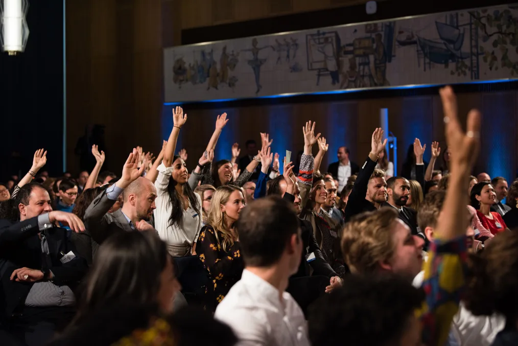 Attendees at a town hall in Berlin raise their hands, eager to discuss the future of Europe with President Obama.