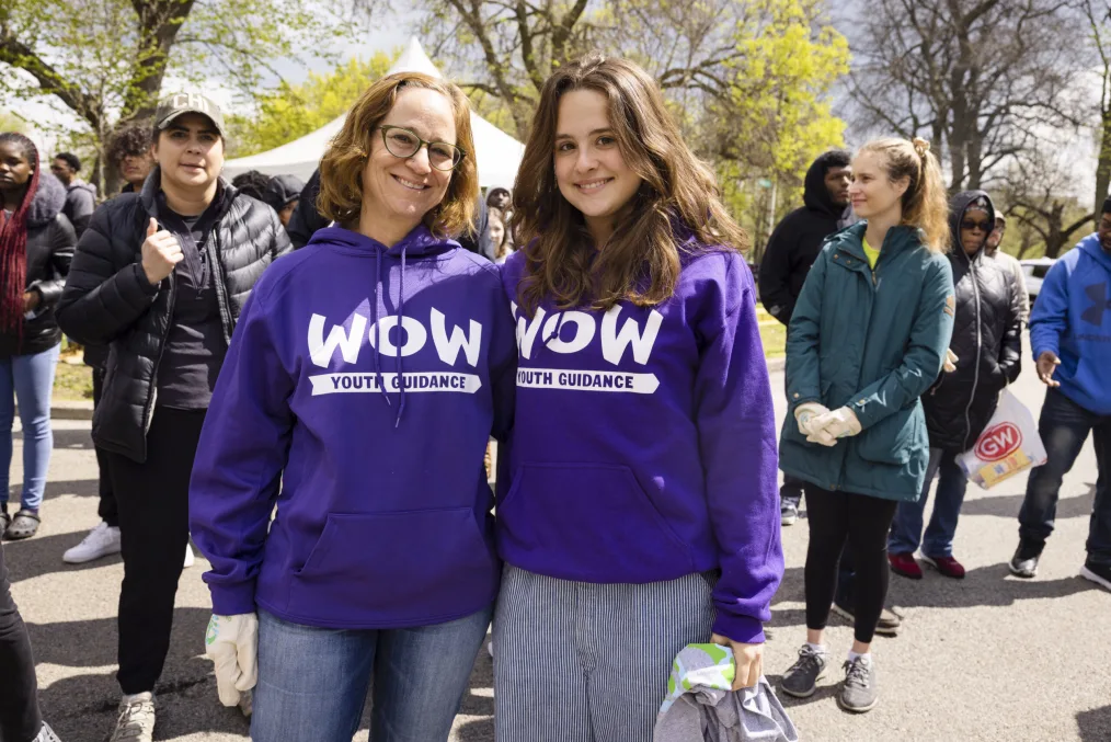 A mother and daughter in matching purple hoodies that read,  “WOW” and “Youth Guidance” in large white letters.