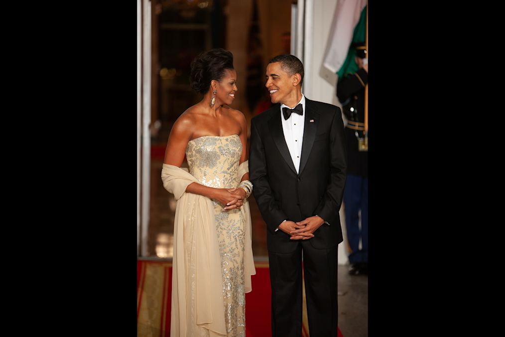 Mrs. Obama, in a gold gown, smiles at President Obama during the first state dinner hosted by the Obama administration. (Official White House Photo by Chuck Kennedy)