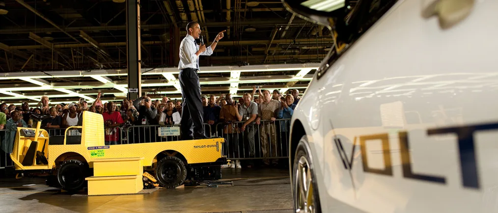 President Obama stands on a yellow truck speaking to ralliers.