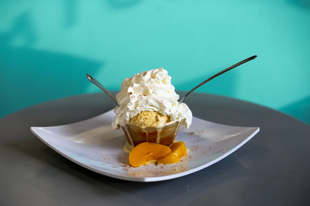Peach cobbler topped with vanilla ice cream.