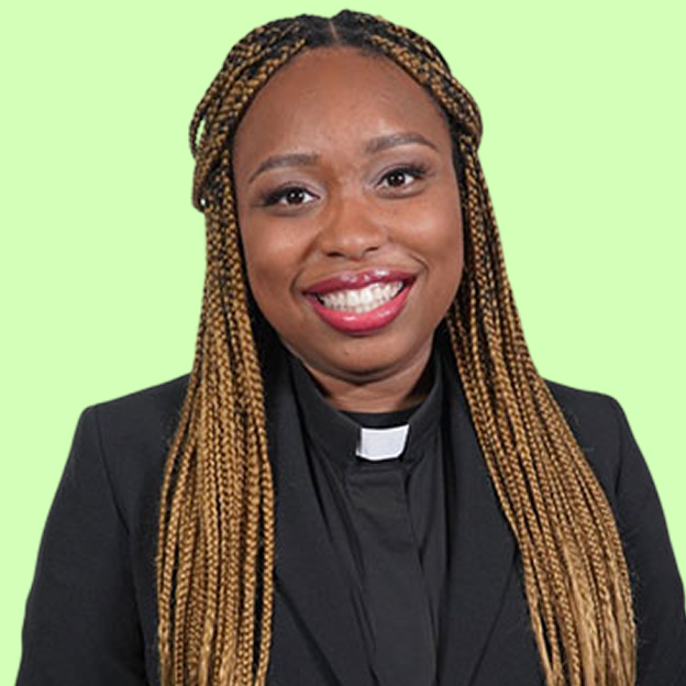The image is a headshot of Reverend Ciera Bates-Chamberlin. Ciera has a medium deep skin tone, brown eyes, and long blonde box braids that fall past her shoulders. She is smiling in the picture. Ciera is wearing a preachers robe. The robe is black with a white collar and a black shirt underneath. The background of Ciera's image is the color light green.