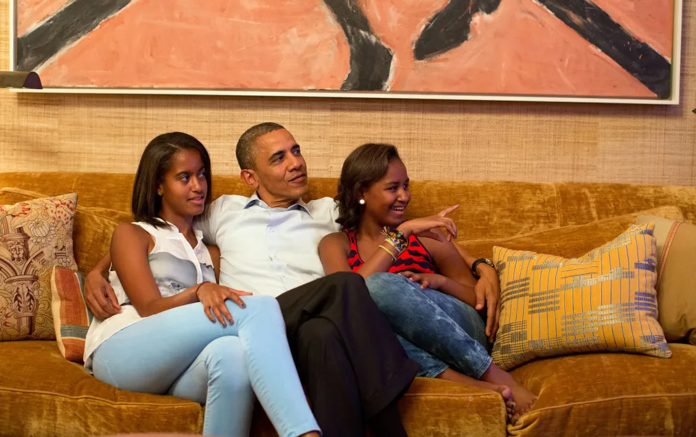 President Barack Obama and his daughters, Malia, left, and Sasha, watch on television