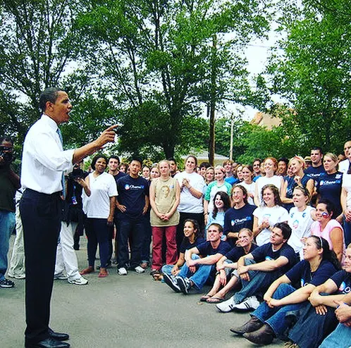 President Obama speaks to a group of young people outdoors.