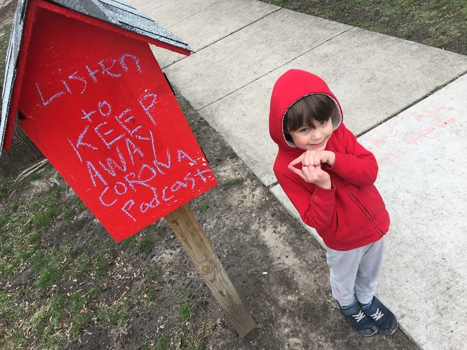 Five-year-old Chicagoan Albie smiles to camera wearing a red hoodie.