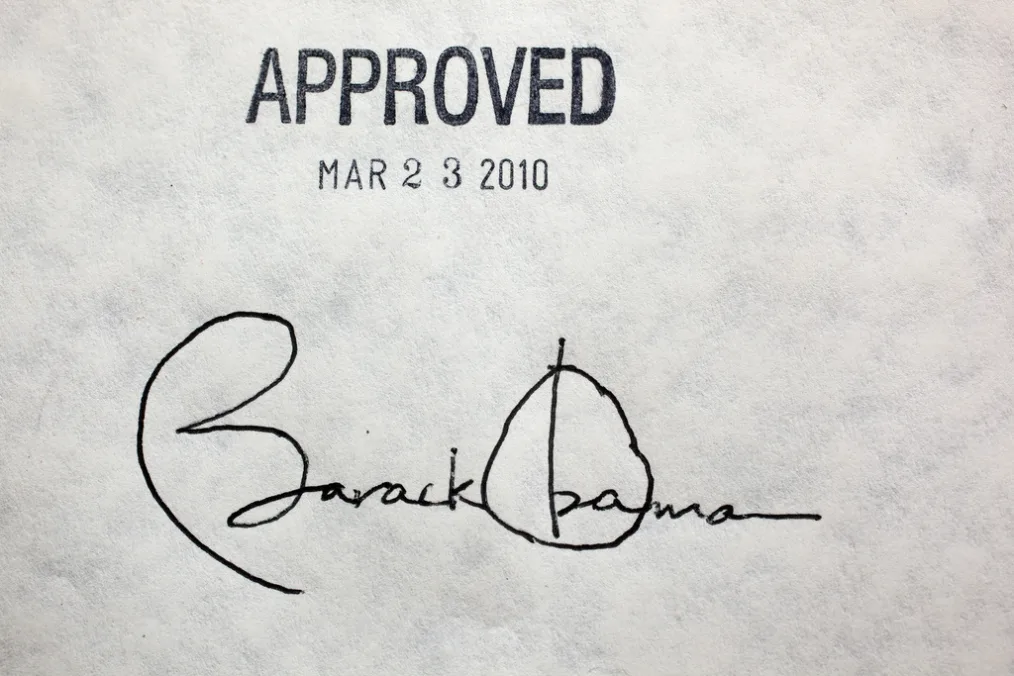 A paper marked "APPROVED" at the top with the text "MAR 2 3 2010" below it in slightly smaller letters. Farther below this text is President Barack Obama's signature signed largely. 