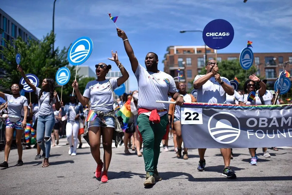 Parade-goers cheer as they walk.