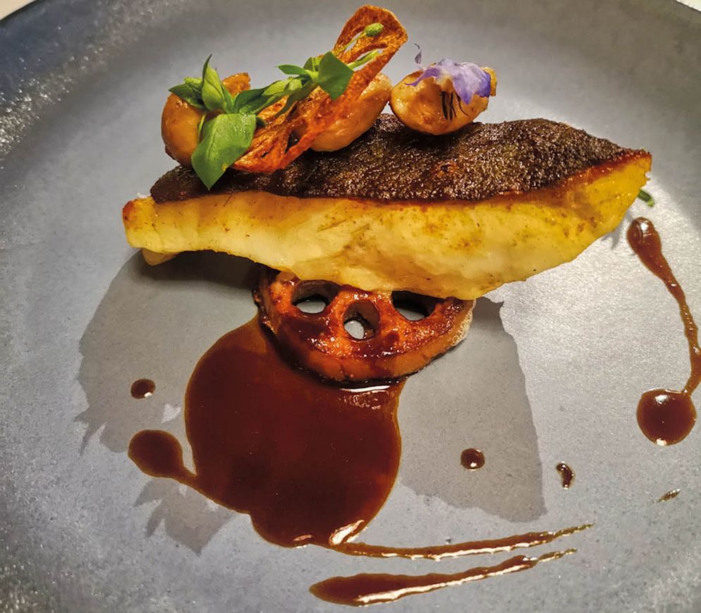 Genuss pur im Restaurant «Nova» im Hotel «l'Etoile» in Charmey: Bretonnischer Steinbutt mit Sot 'y laisse (zarte Pouletstückchen) und Lotus an einer Syrah-Sauce