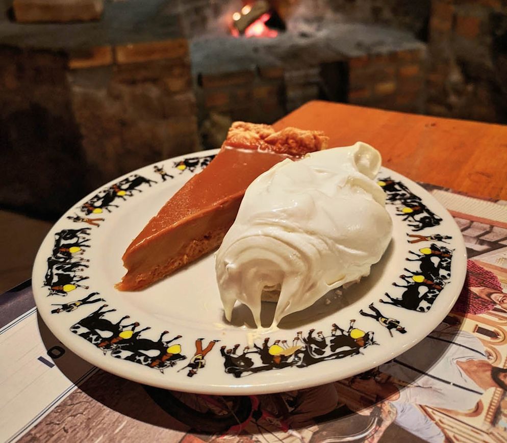 Feine Tarte au vin cuit und Meringue mit Doppelrahm in der heimeligen Buvette «Au Creux du Feu» in Broc.