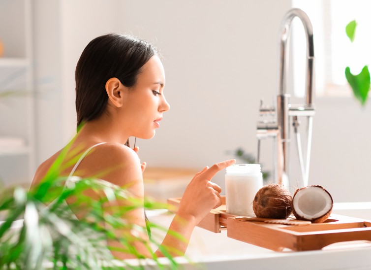 mujer con aceite de coco frente a espejo
