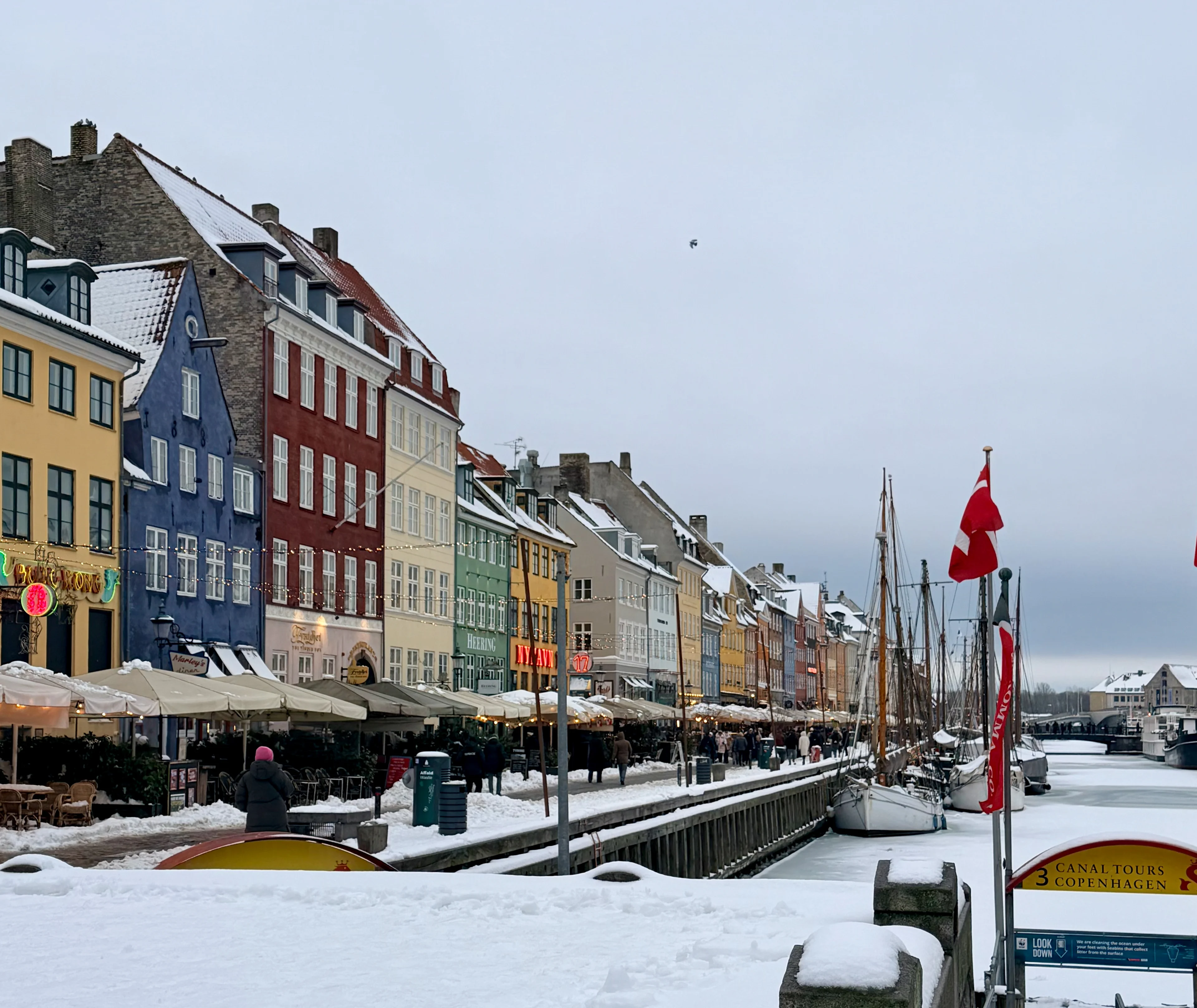 The colorful waterfront of Nyhavn in Copenhagen, with historic buildings and boats.