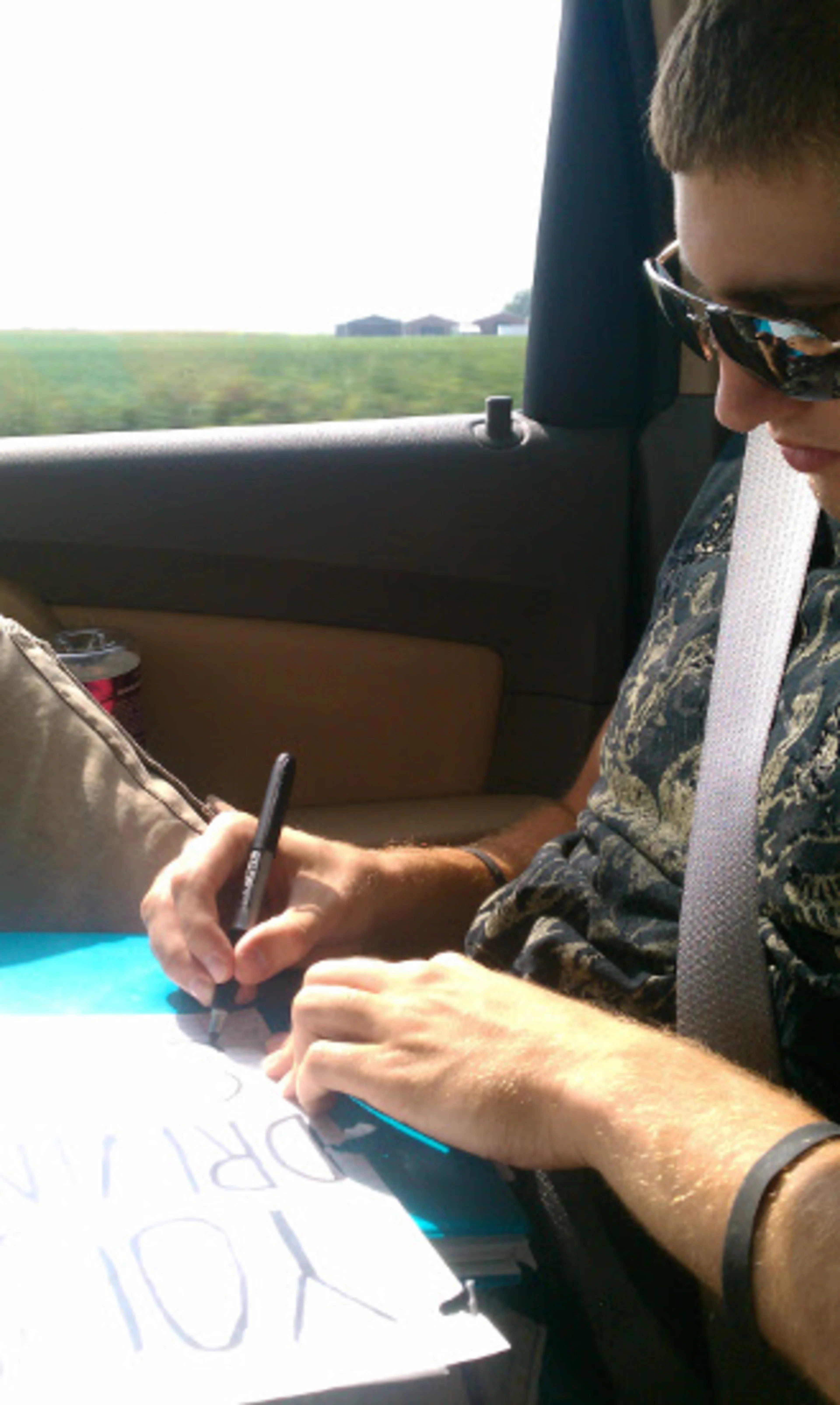 My brother making a sign that says "Your Driving Sucks"