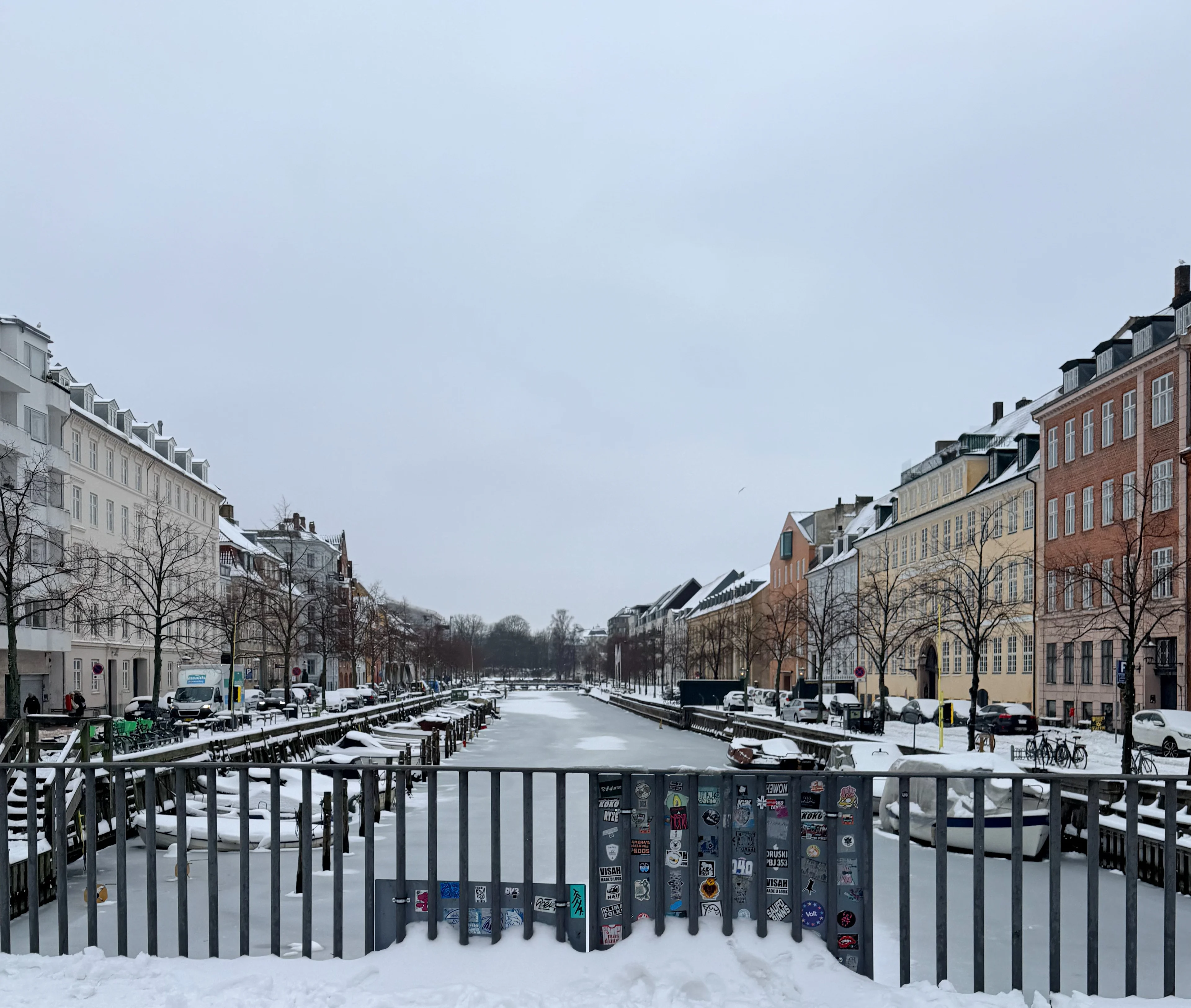 A frozen canal in Copenhagen in winter, with snow along the banks.