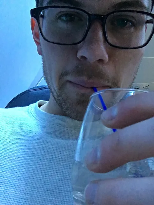 Sipping on a cocktail in first class, during my first non-economy experience