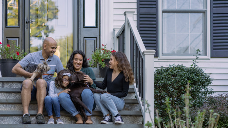 Family with dogs on their front steps