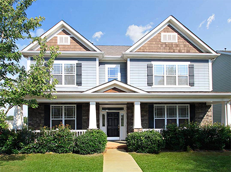 two story house with covered porch and lots of windows