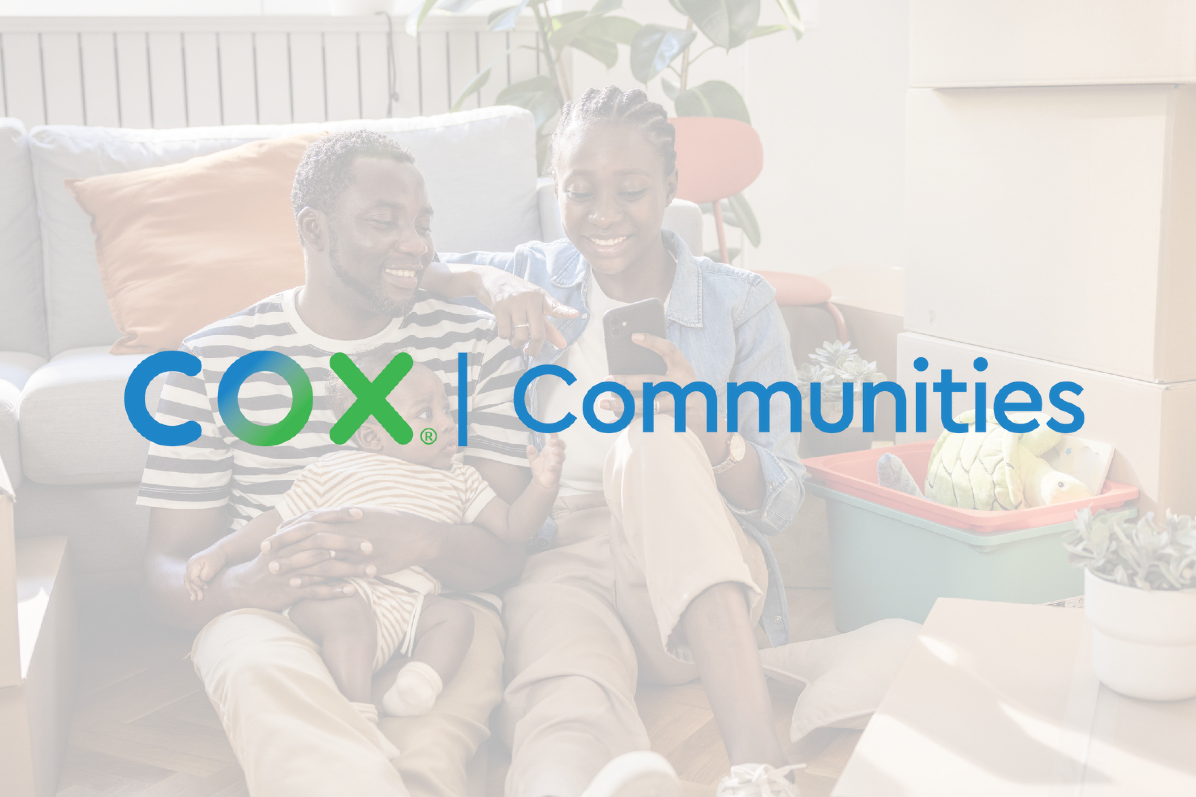 A young couple with their baby smiling at their phone, there is a COX logo over the image