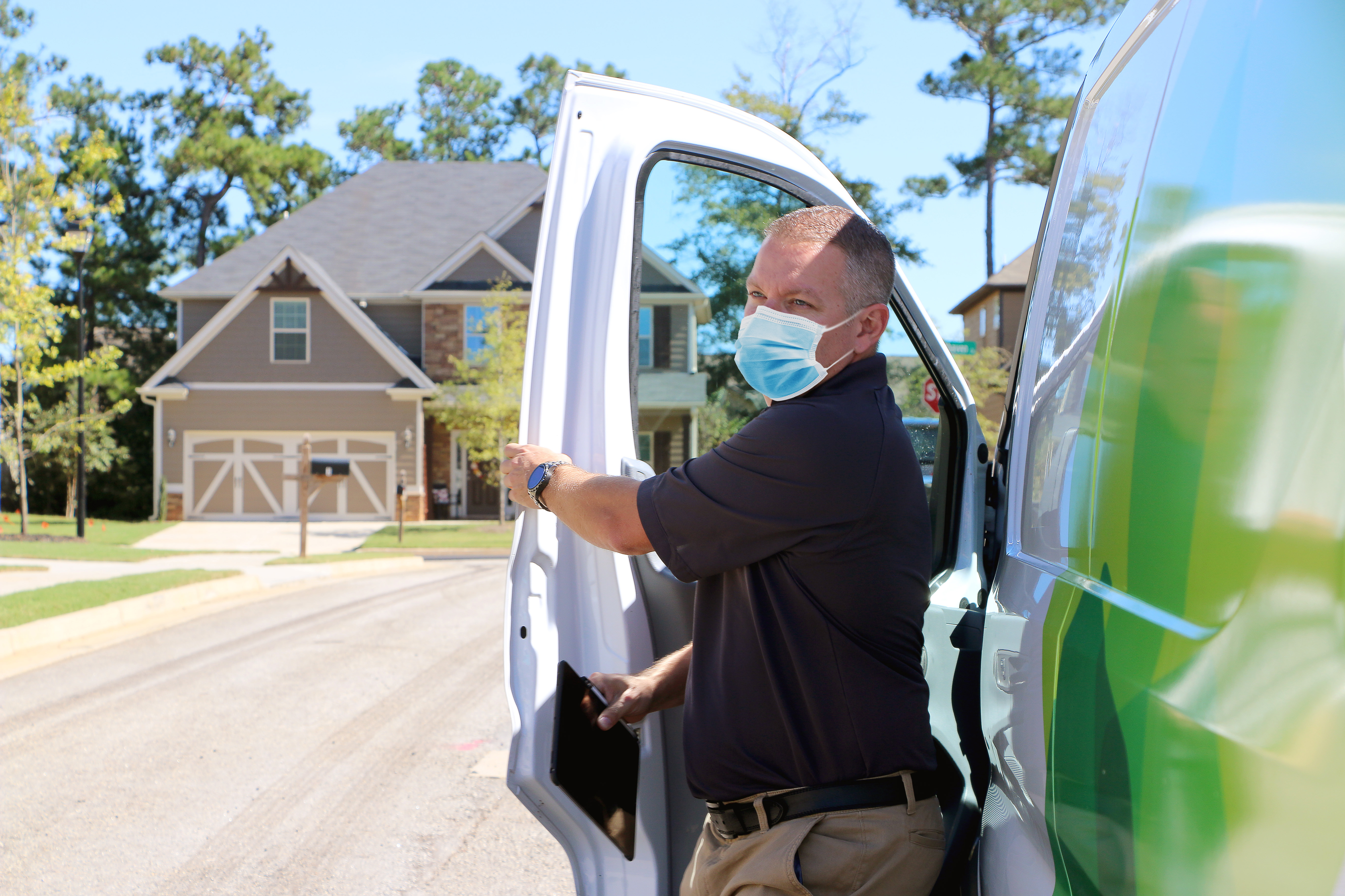 A maintenance tech steps out of a van