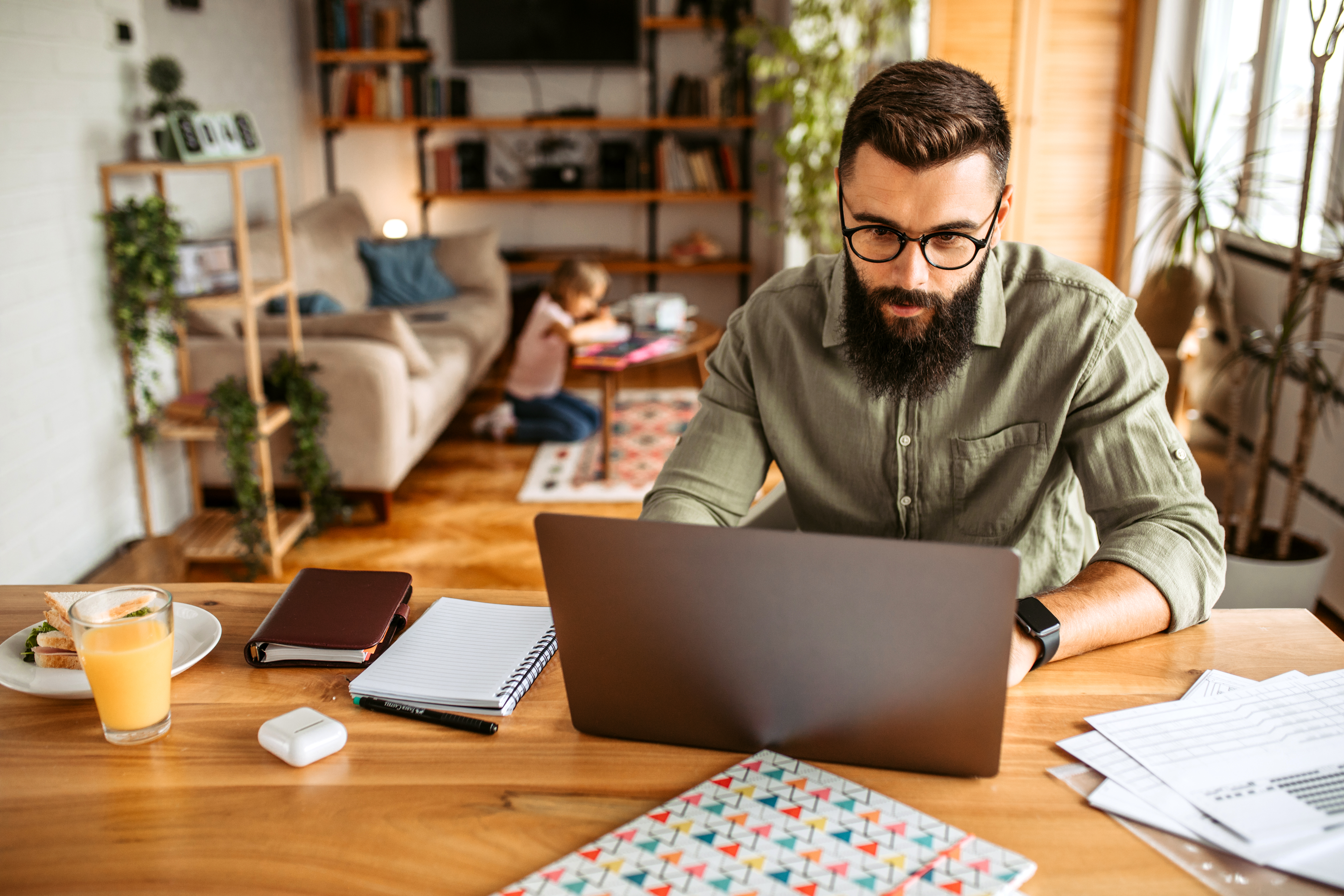 A man sits at a table with a laptop