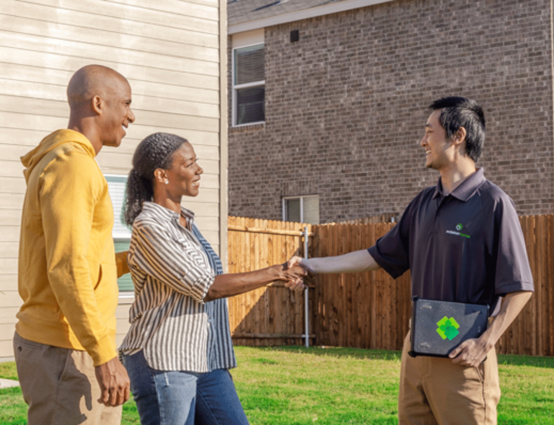 An Invitation Homes maintenance tech greets a woman and a man. 