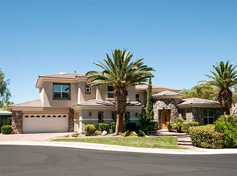 Las Vegas rental home with a two-car garage and palm trees outside.