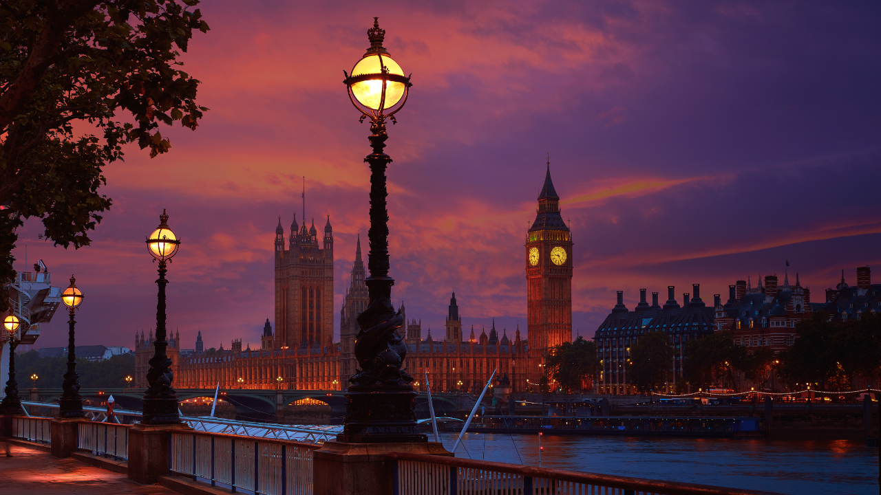 https:Illuminated Big Ben and Houses of Parliament at night. Must-see landmarks on a London vacation.