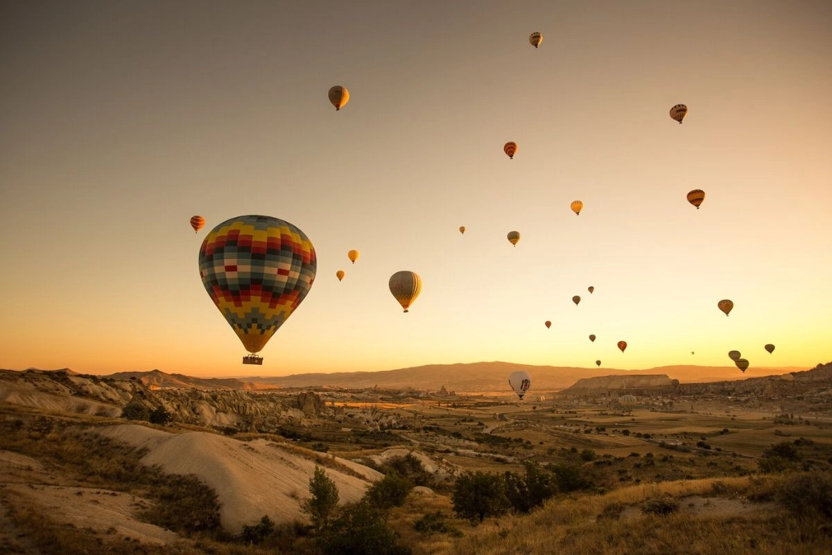 Hot air balloons over the unique rocky landscapes of Cappadocia during autumn, a top Europe fall destination.