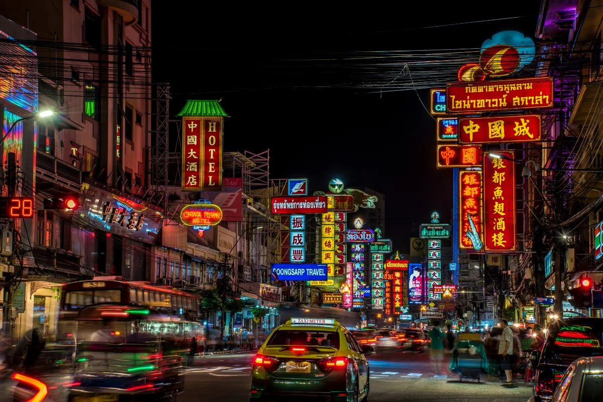 https:A stunning view of Sukhumvit, Bangkok's bustling district known for its shopping, dining, and nightlife, with modern skyscrapers illuminated at dusk."