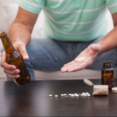 Man mixing beer with his medicine