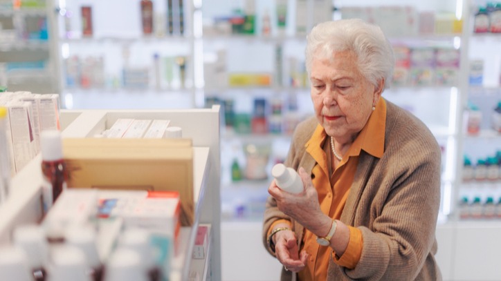 Mature woman in pharmacies comparing antibiotic prices