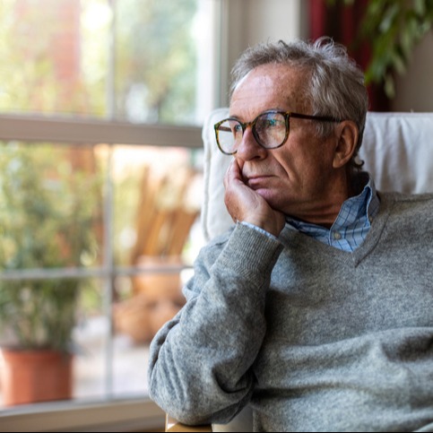 Senior man looking out of window at home