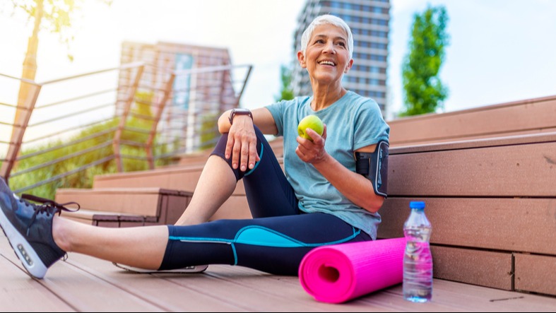 Smiling woman eating green apple