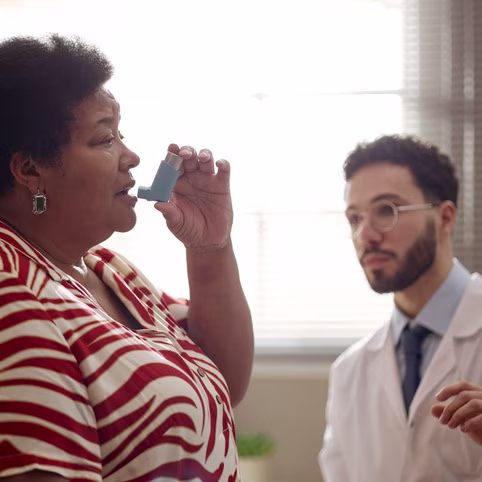  Woman Using an Inhaler During Medical Consultation