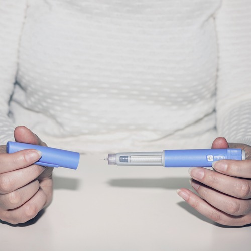Woman holding an injection pen for diabetic.