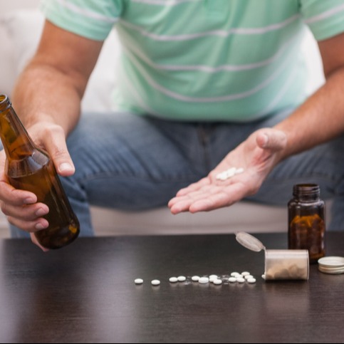 Man mixing beer with his medicine