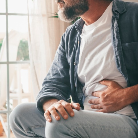 A mature man presses his belly with stomach pain from taking Ozempic for weight loss