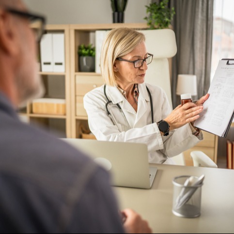 Female Doctor Holding Medication and Medical Document, Explaining to Patient