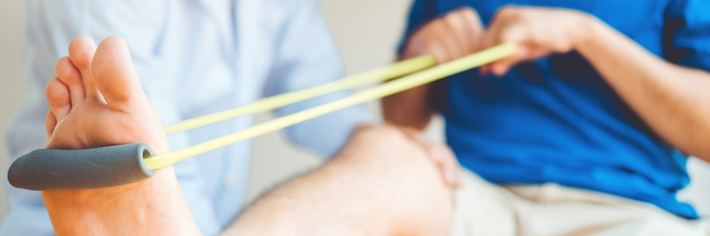 Physiotherapist man giving resistance band exercise