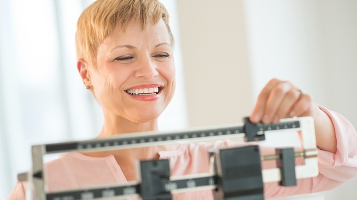 Happy Woman Adjusting Balance Weight Scale